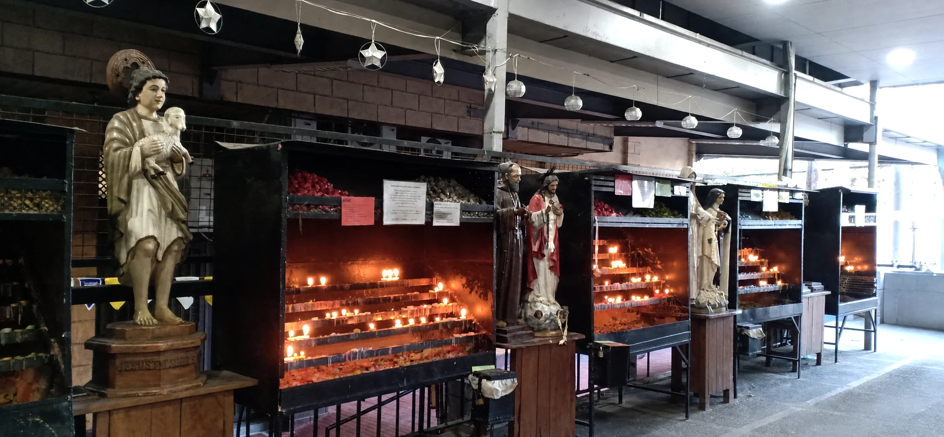 Devotional candles and saint statues inside the church