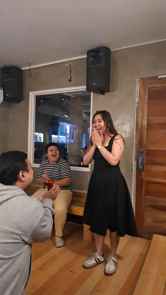 Carlo proposing to Maila as their friends celebrate