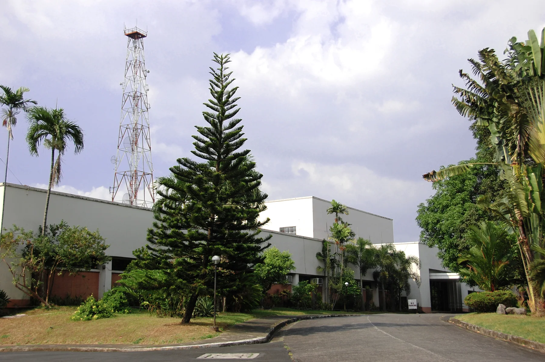 Radio Veritas Asia courtyard with tower, palms, and landscaped driveway